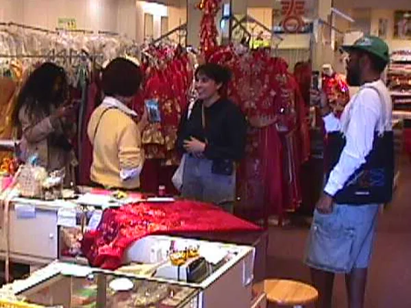 Five Photo Phloor members on the walk, shooting among racks of red qipao in a Chinatown shop